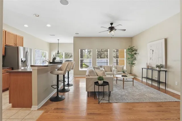 a kitchen with stainless steel appliances granite countertop a stove a sink a microwave a refrigerator white cabinets and a refrigerator