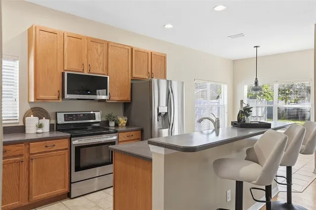 a kitchen with stainless steel appliances kitchen island granite countertop a stove a sink and a refrigerator