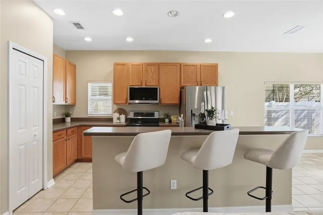 a living room with furniture and a flat screen tv with kitchen view