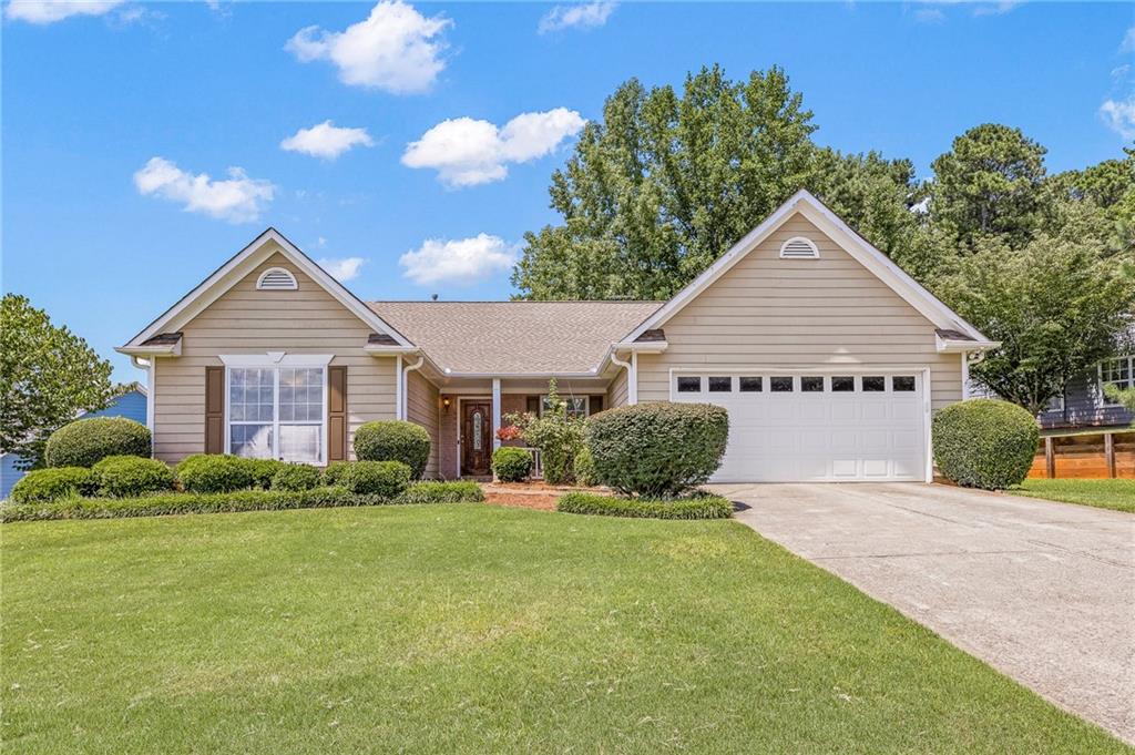 a view of a house with a yard and potted plants