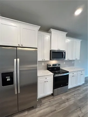 a kitchen with cabinets stainless steel appliances and a counter space