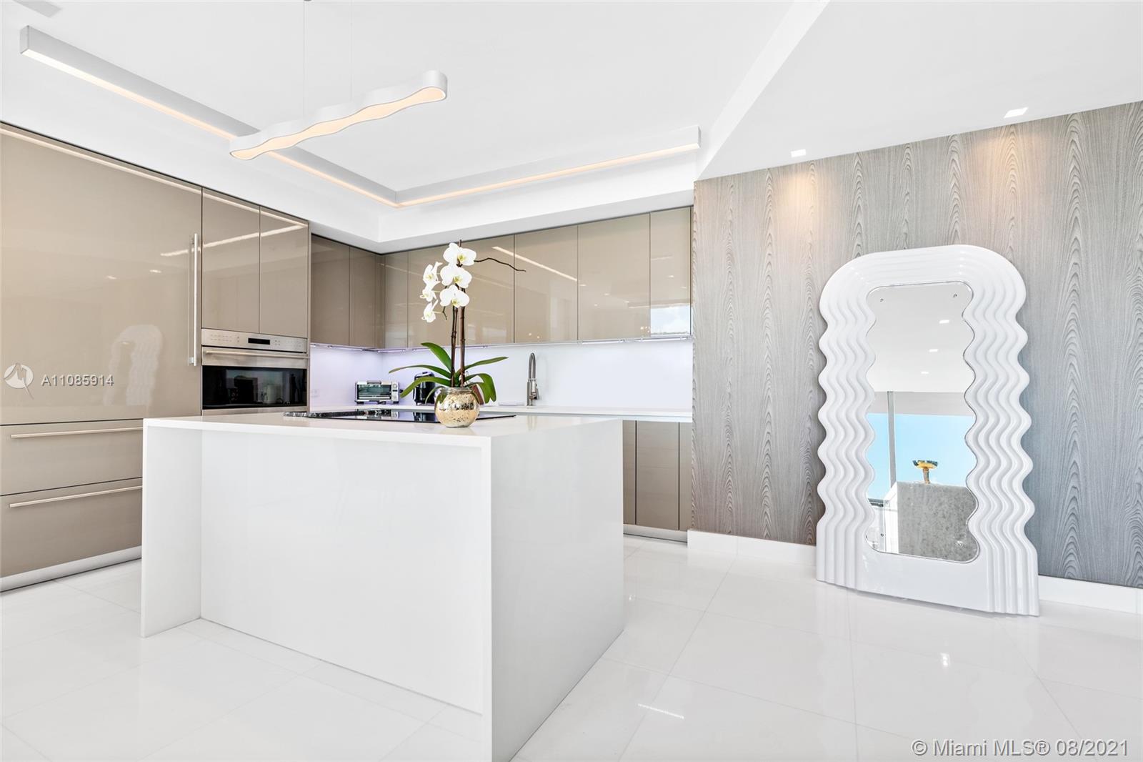 1201 20th Street, Unit PH08 Miami Beach, FL 33139 - Photo 9 of 28 a white kitchen with cabinets and a refrigerator