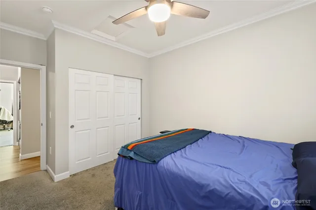 a bedroom with a bed and a chandelier fan
