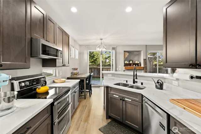 a kitchen with stainless steel appliances a sink a stove and cabinets