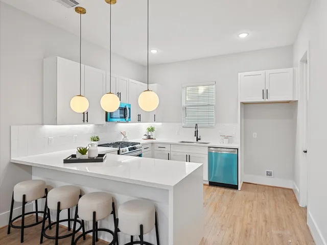 a kitchen with a sink cabinets and dining table chair