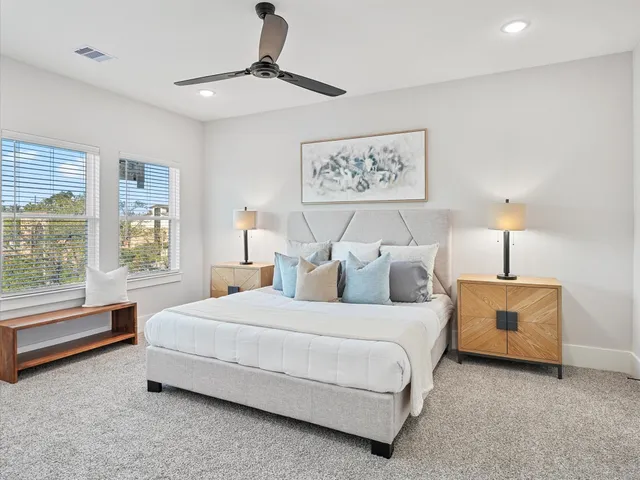 a bedroom with a bed painting on wall and a large window