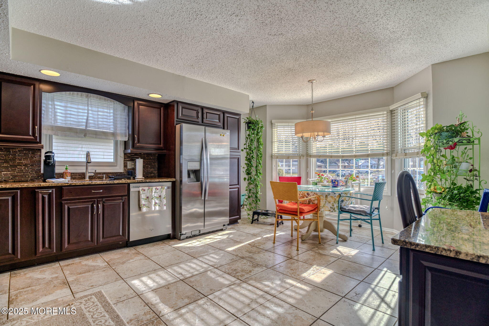 16 Deer Run Lane Brick, NJ 08724 - Photo 8 of 41 a kitchen with stainless steel appliances granite countertop a refrigerator a stove a sink dishwasher and a dining table with garden view