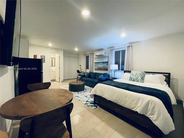 a spacious bedroom with a bed a table and chair