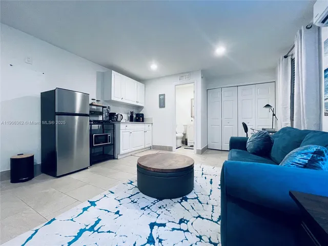 a living room with a couch and a refrigerator
