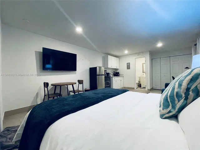 a large bedroom with a bed and a flat screen tv