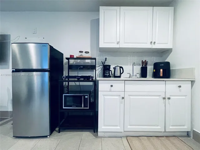 a kitchen with refrigerator and cabinets