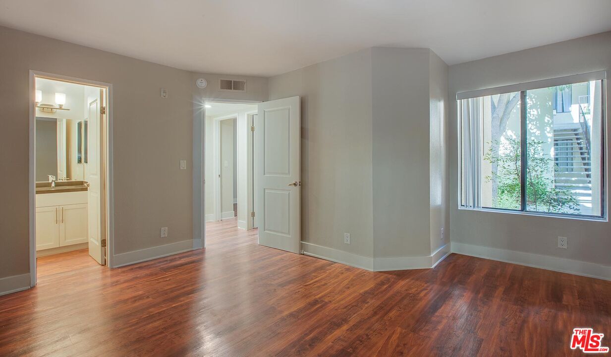 5922 Las Virgenes Road, Unit 566 Calabasas, CA 91302 - Photo 7 of 8 an empty room with wooden floor and windows