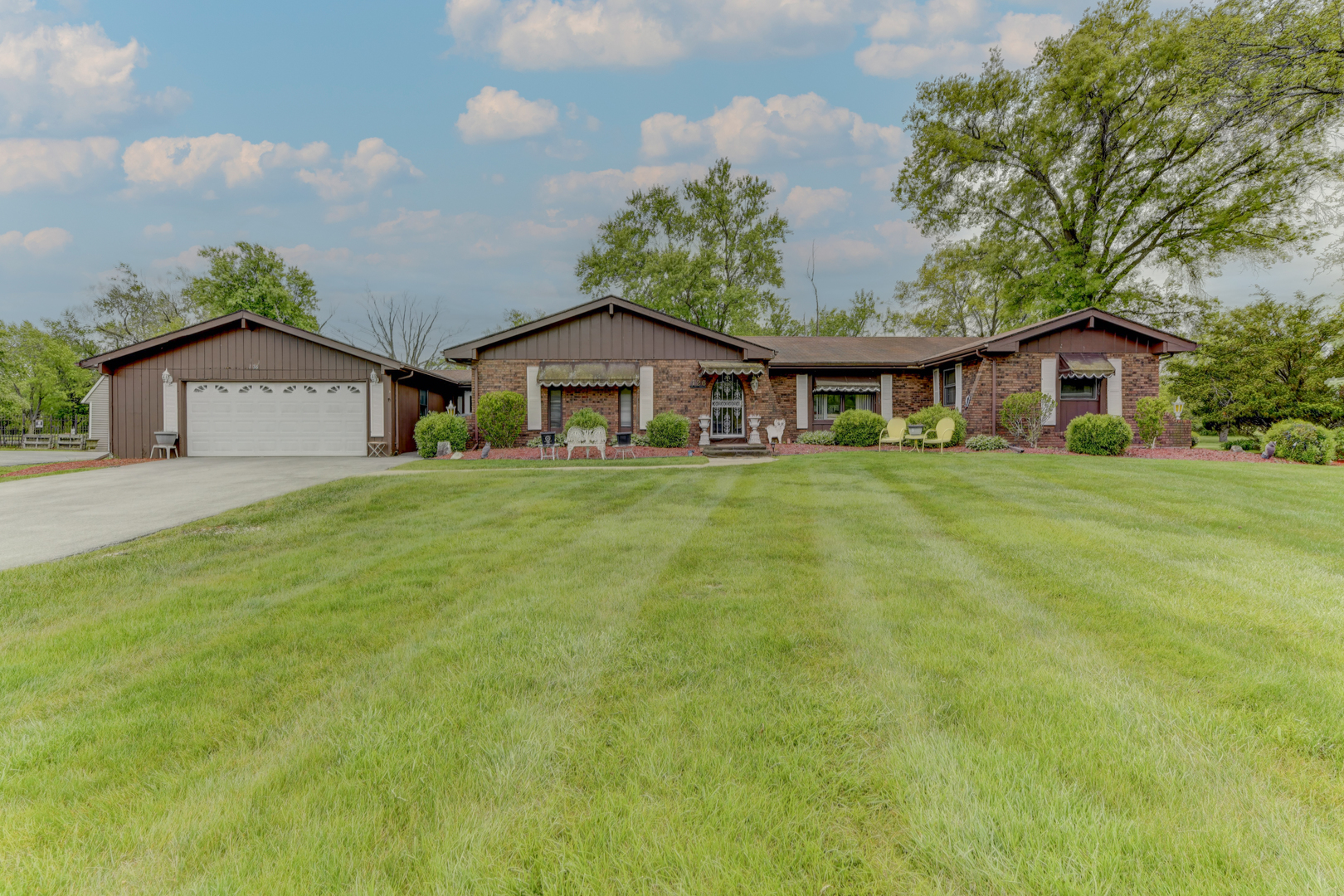 a view of a house with a big yard and large trees