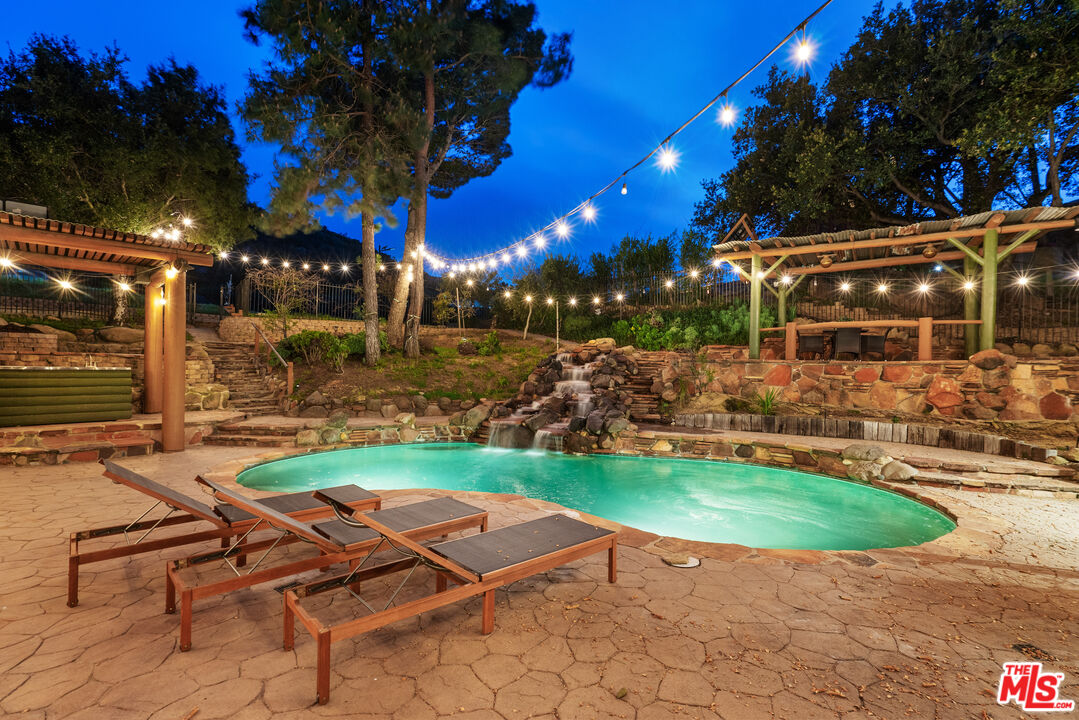 a view of backyard with swimming pool and outdoor seating