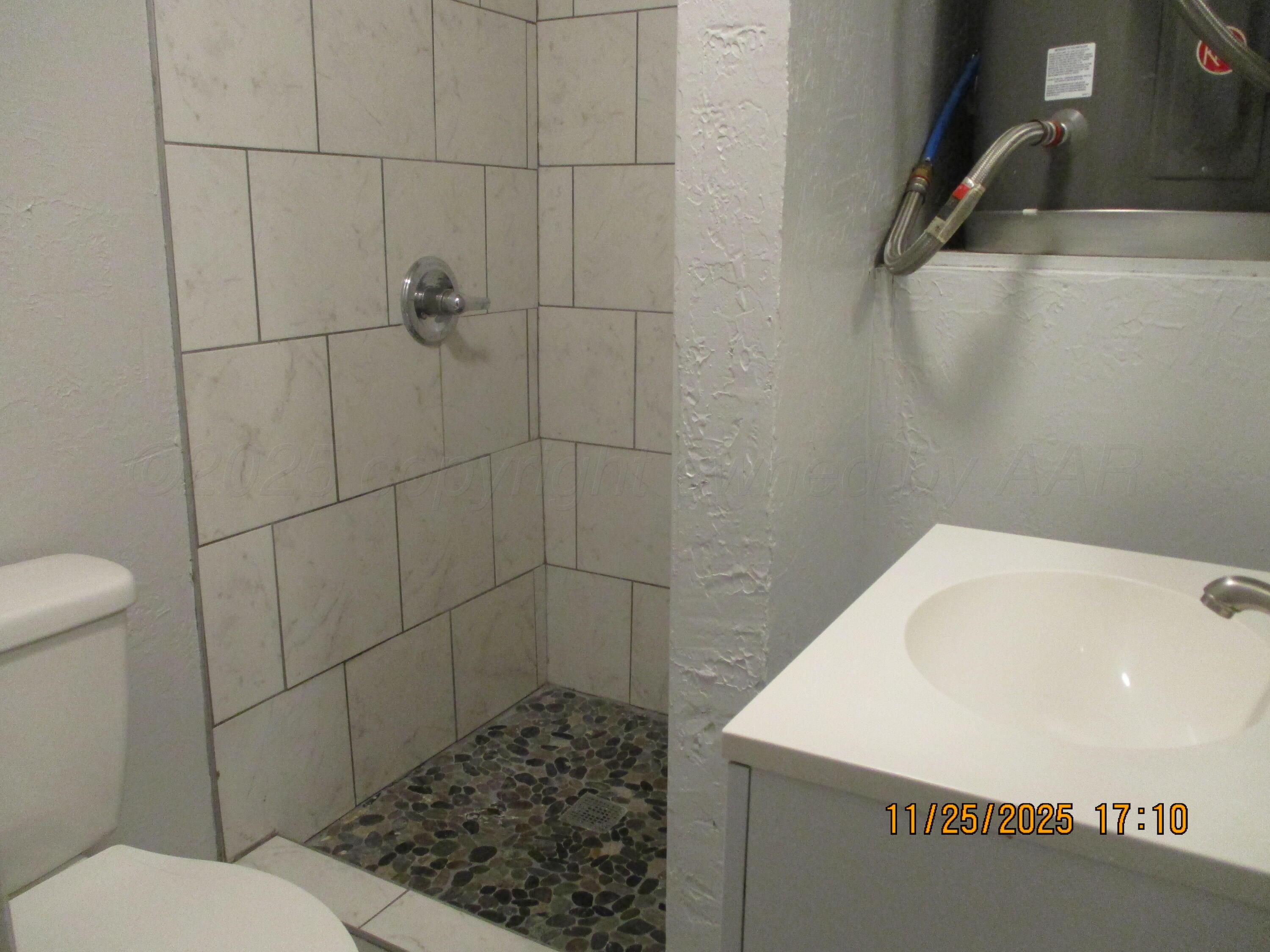 3811 Southeast 14th Avenue Amarillo, TX 79104 - Photo 4 of 6 a bathroom with a sink a toilet and shower