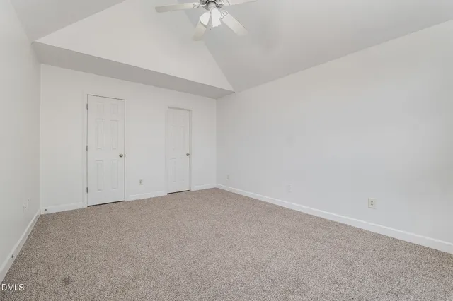 an empty room with a chandelier fan