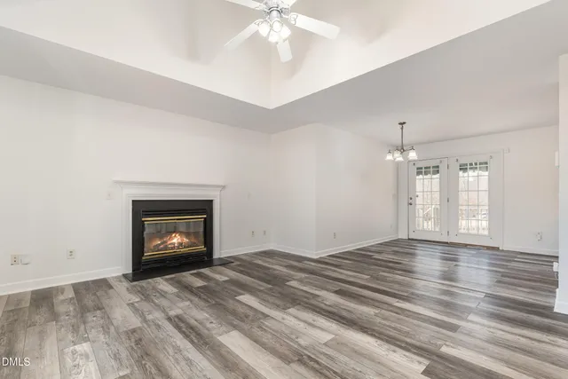 an empty room with windows and fireplace
