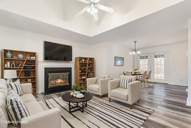a living room with furniture a fireplace and a flat screen tv