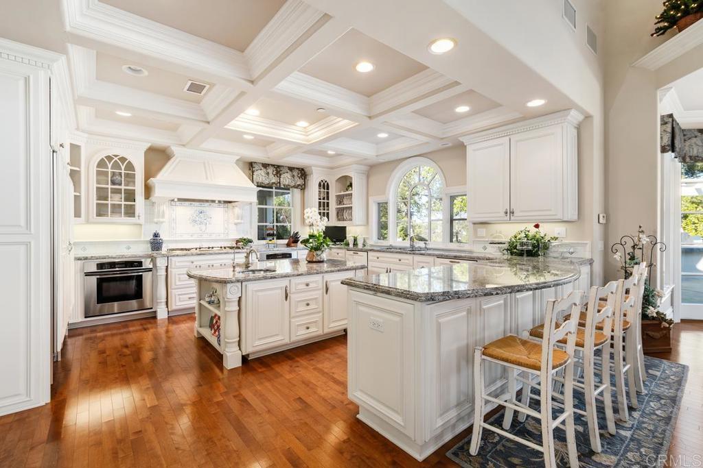 3056 Wildflower Drive Encinitas, CA 92024 - Photo 19 of 56 a kitchen with stainless steel appliances kitchen island granite countertop a stove a sink and a refrigerator