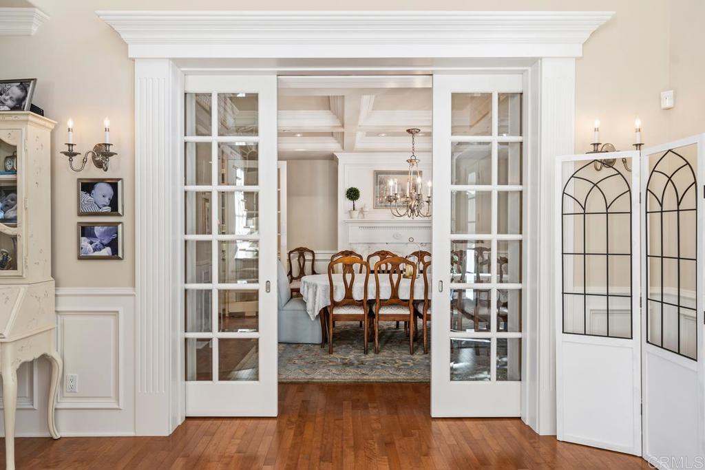 3056 Wildflower Drive Encinitas, CA 92024 - Photo 23 of 56 a dining room with wooden floor and a floor to ceiling window