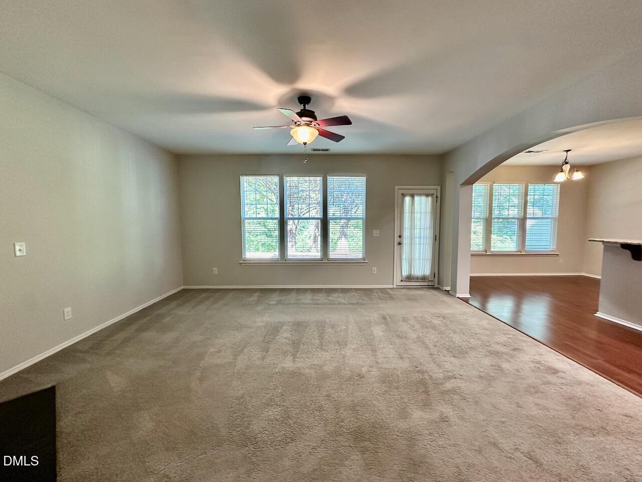 8208 Stone Cellar Drive Raleigh, NC 27613 - Photo 8 of 34 an empty room with chandelier fan and windows