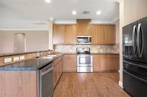 a kitchen with stainless steel appliances granite countertop a sink stove and refrigerator