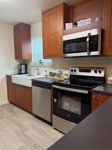 a kitchen with stainless steel appliances a stove microwave and sink