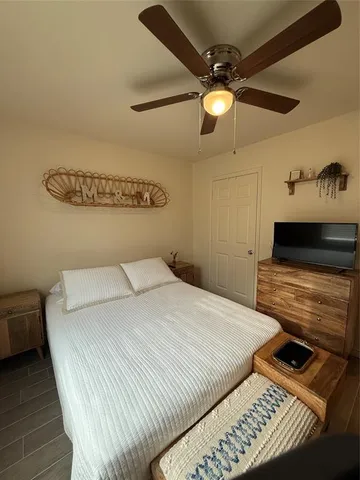 a bedroom with a bed and a ceiling fan