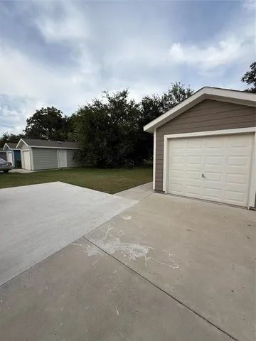 a view of backyard of house and car parked