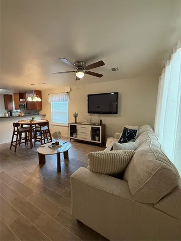 a living room with furniture a view of the kitchen