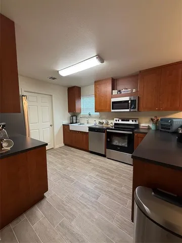 a large kitchen with stainless steel appliances granite countertop a stove and a sink