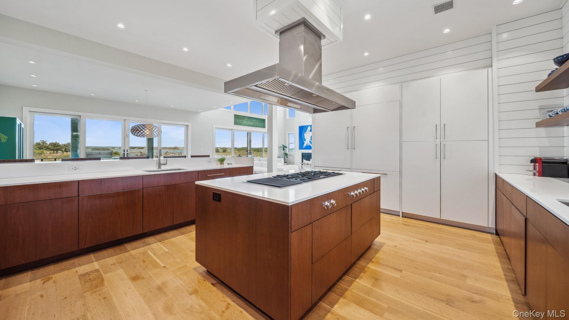 102-92 Dune Road Westhampton Beach, NY 11978 - Photo 13 of 40 Kitchen featuring open shelves, a kitchen island, light wood finished floors, recessed lighting, and modern cabinets