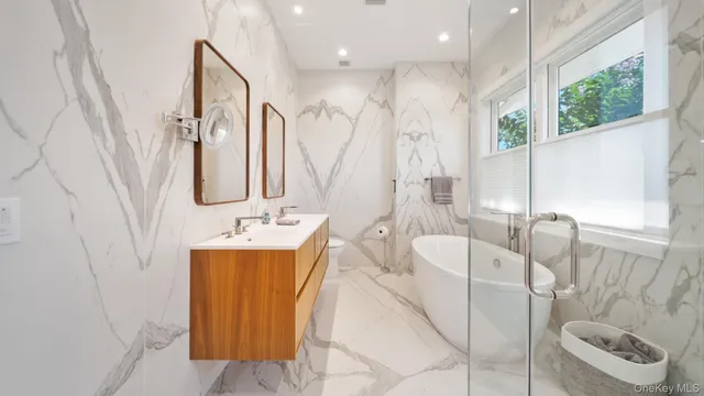 a bathroom with a tub sink and mirror