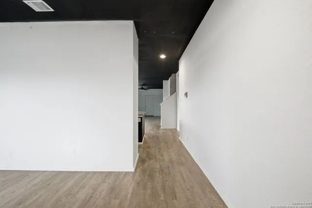 a view of a hallway with wooden floor