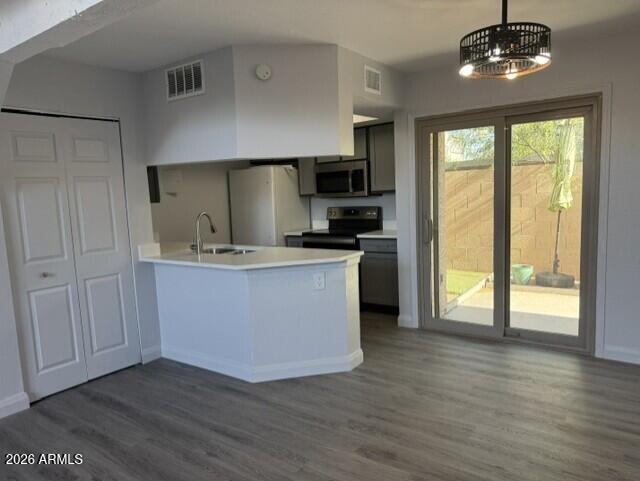 4240 North Longview Avenue, Unit 9 Phoenix, AZ 85014 - Photo 6 of 13 a kitchen with stainless steel appliances granite countertop a stove top oven a sink with wooden floors and cabinets