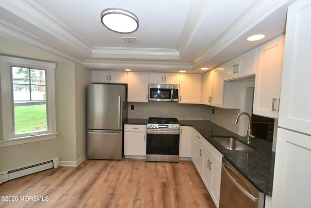 a kitchen with granite countertop a refrigerator stove and sink