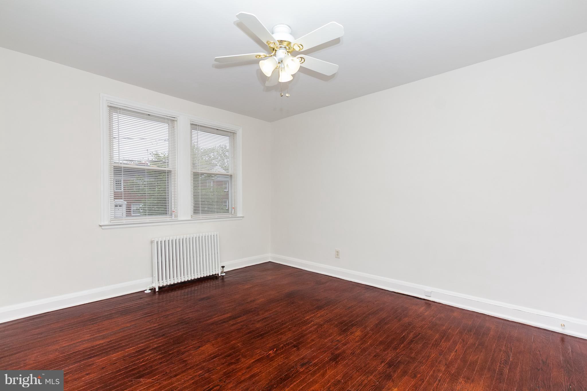 5228 Old Frederick Road Baltimore, MD 21229 - Photo 11 of 28 an empty room with wooden floor and windows