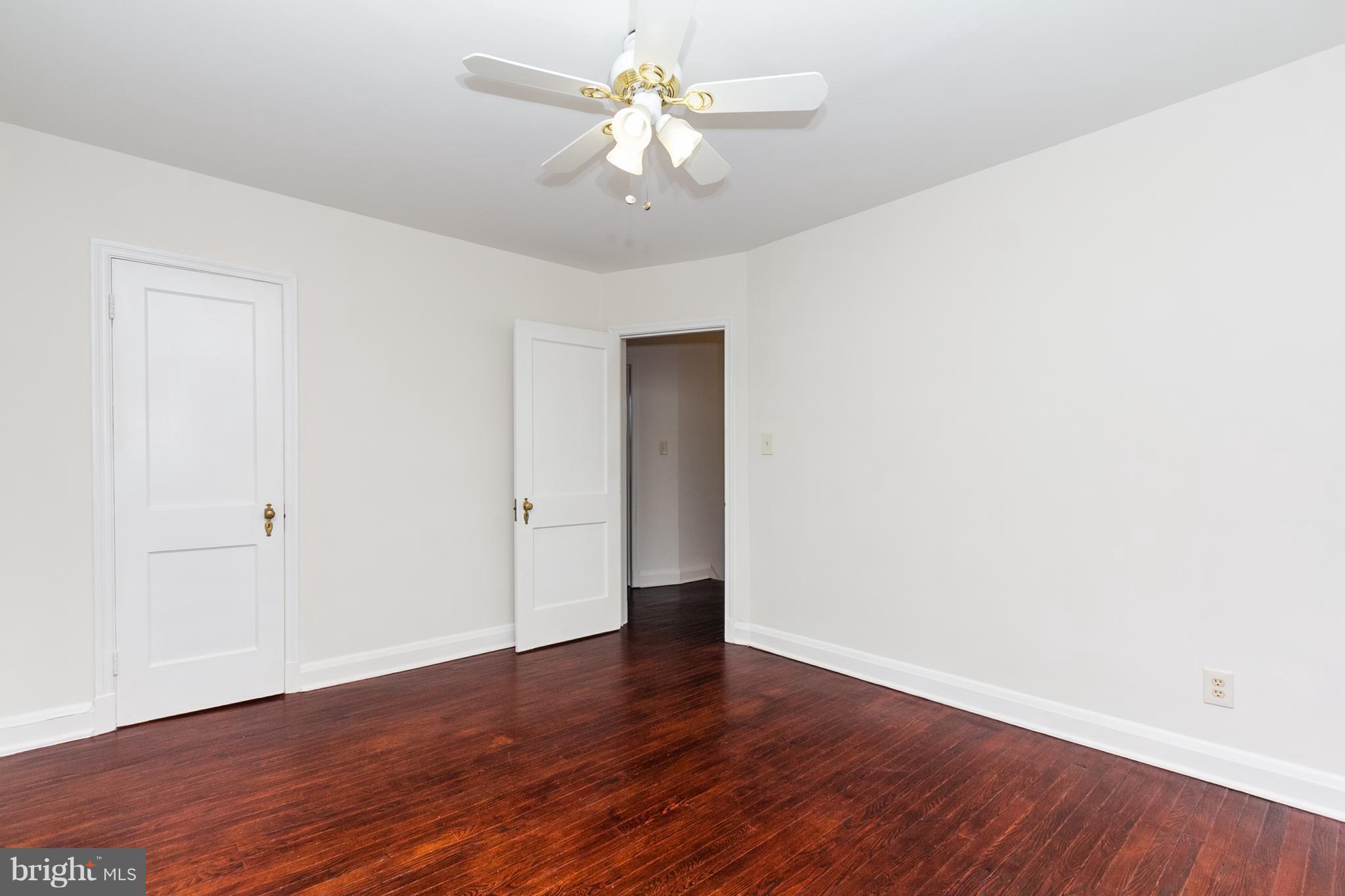 5228 Old Frederick Road Baltimore, MD 21229 - Photo 12 of 28 a view of a room with wooden floor and a ceiling fan