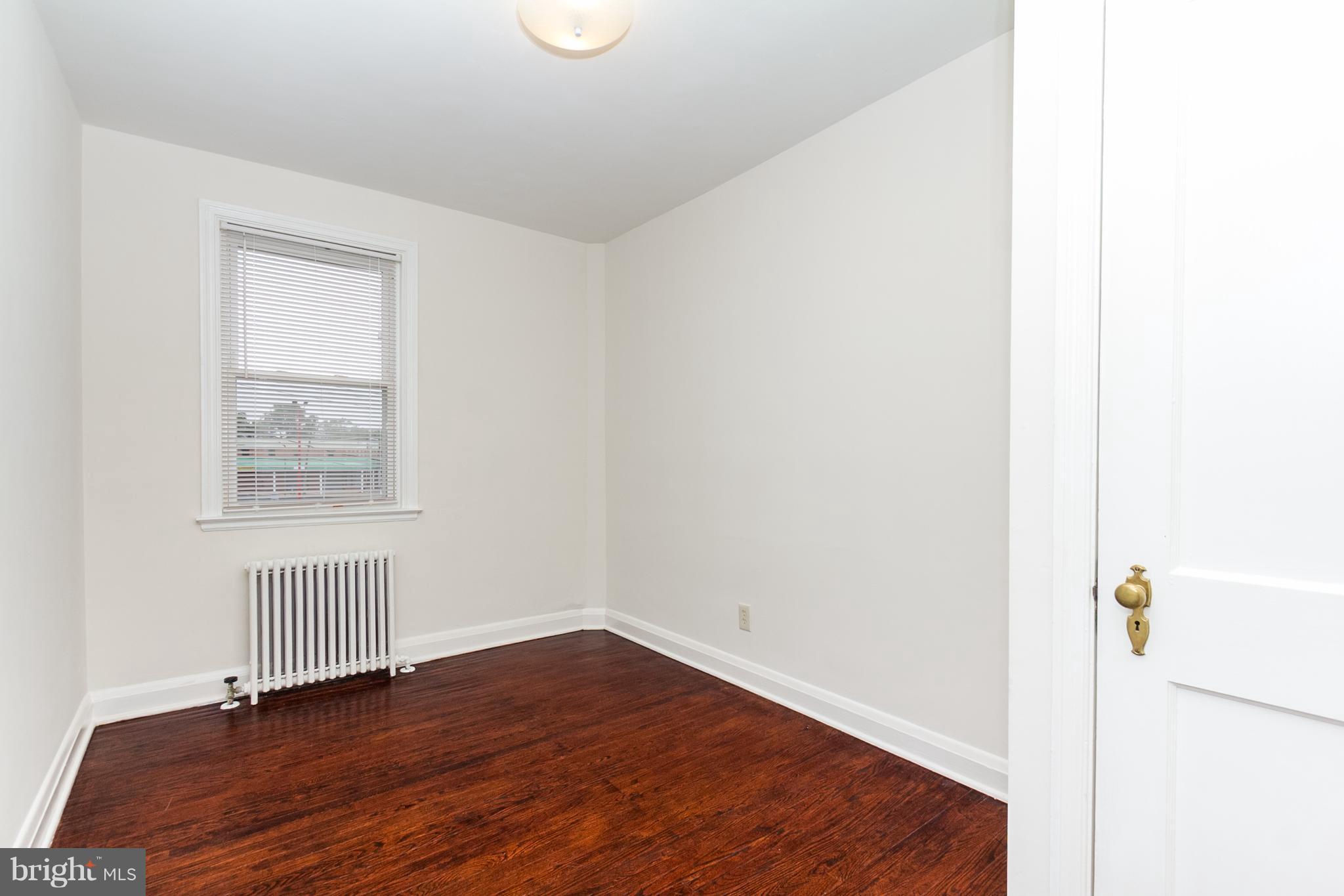 5228 Old Frederick Road Baltimore, MD 21229 - Photo 13 of 28 a view of an empty room with wooden floor and a window