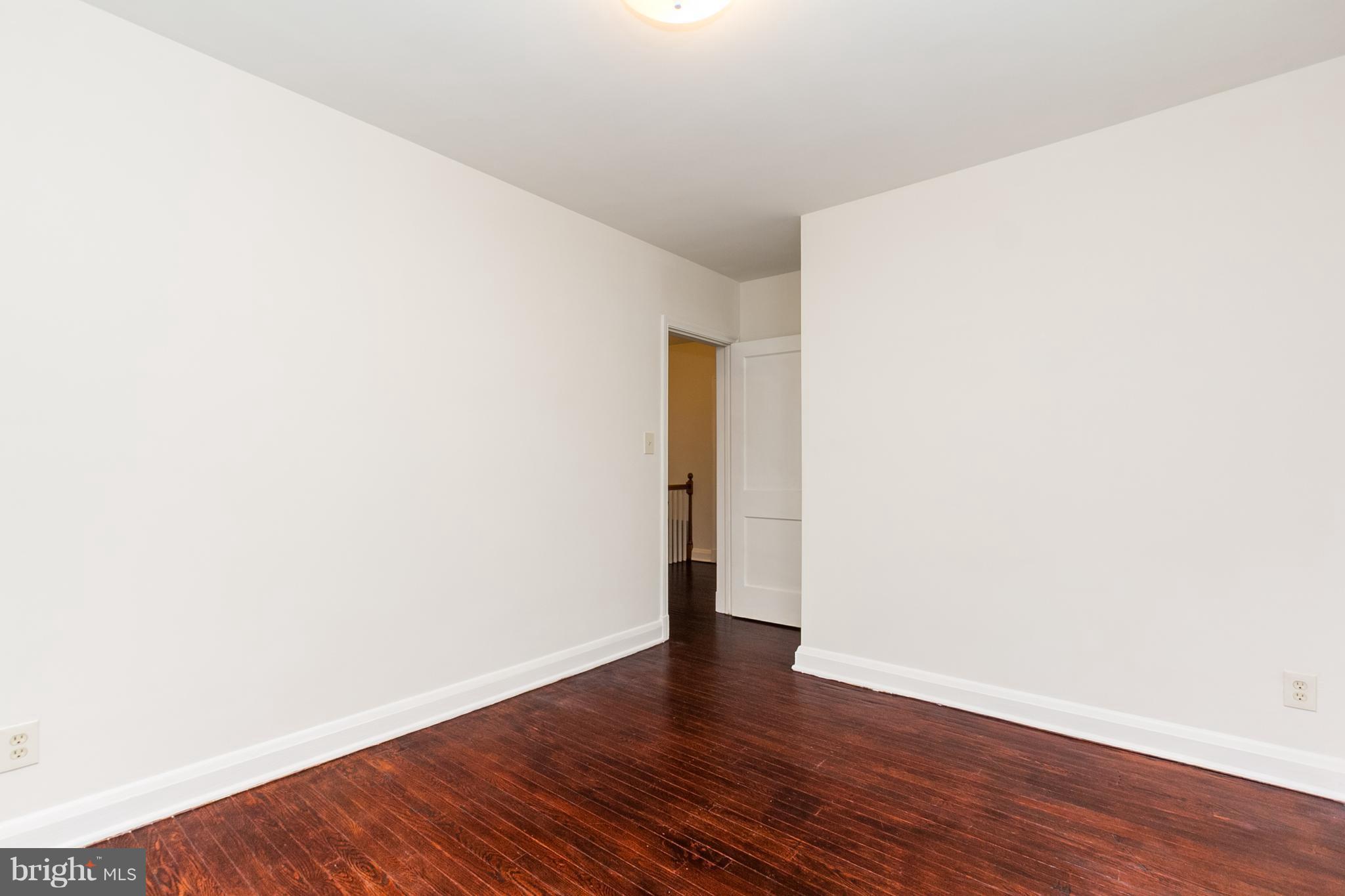 5228 Old Frederick Road Baltimore, MD 21229 - Photo 16 of 28 a view of an empty room with wooden floor