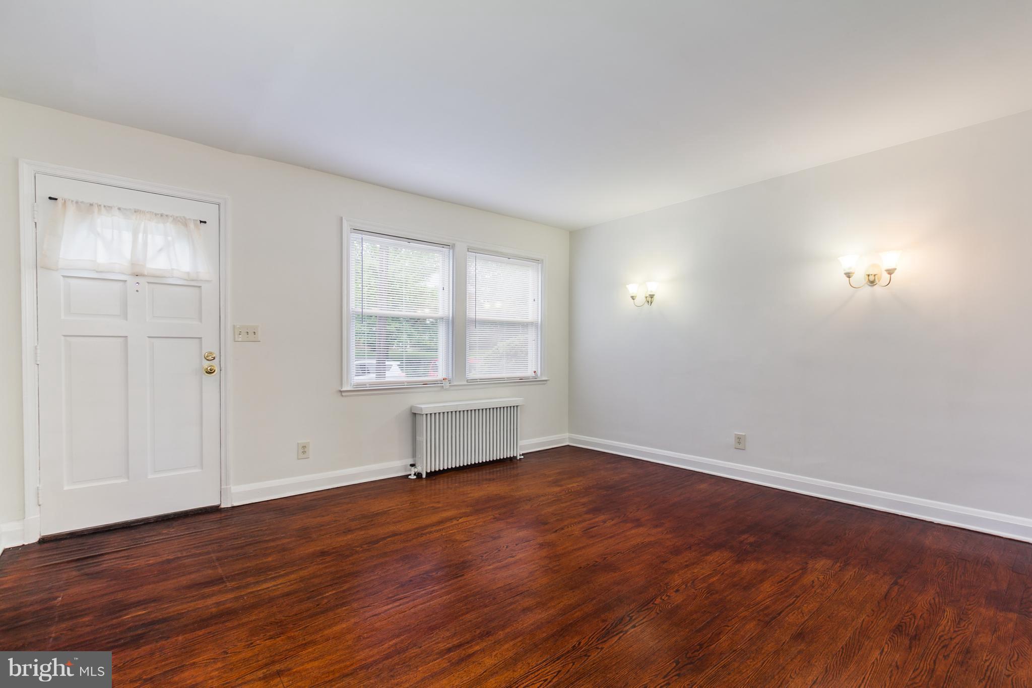 5228 Old Frederick Road Baltimore, MD 21229 - Photo 5 of 28 an empty room with wooden floor and windows