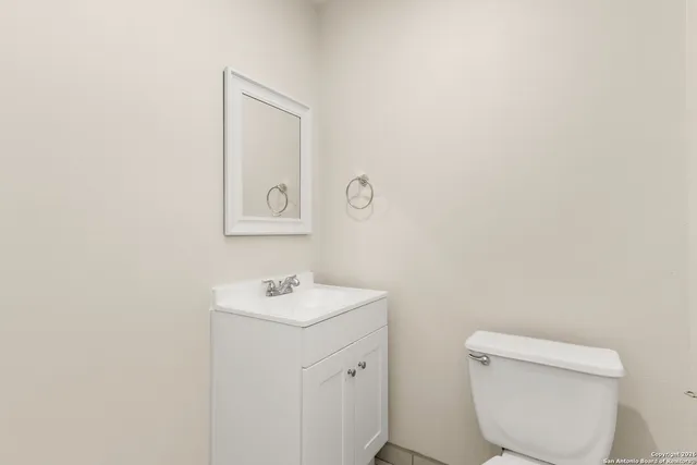a bathroom with a toilet sink and mirror