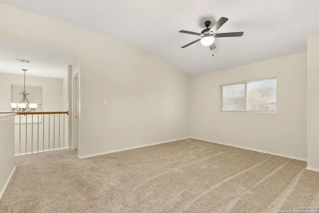 a view of an empty room with a ceiling fan