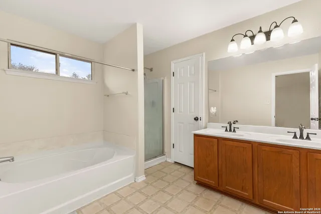 a bathroom with a tub a sink and mirror