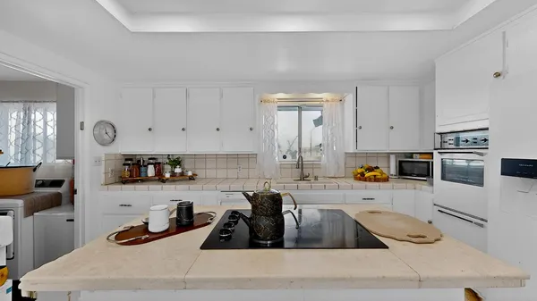 a kitchen with white cabinets and appliances