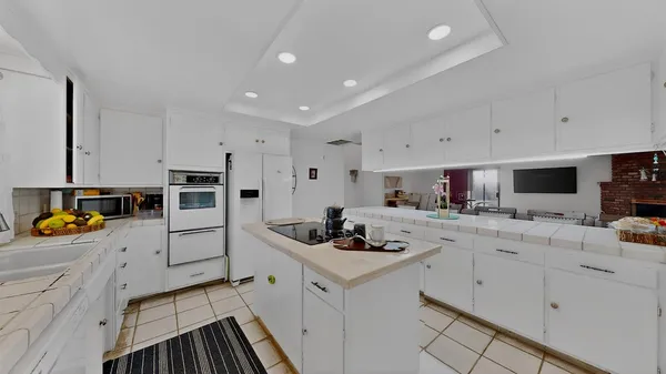 a kitchen filled with white cabinets and appliances