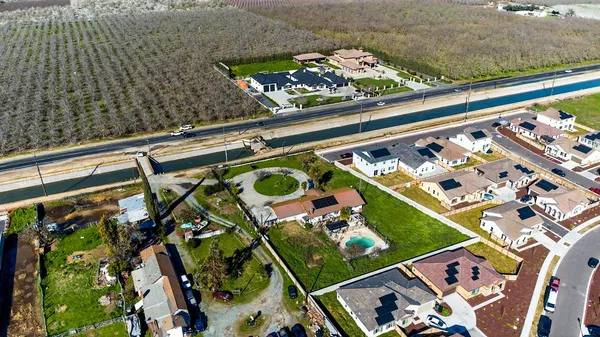 an aerial view of a house with garden space and street view