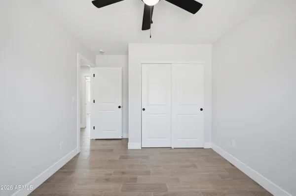 a view of a big room with wooden floor and windows