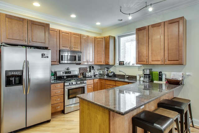 2629 West Haddon Avenue, Unit 2 Chicago, IL 60622 - Photo 3 of 8 a kitchen with stainless steel appliances granite countertop a stove refrigerator sink microwave and cabinets