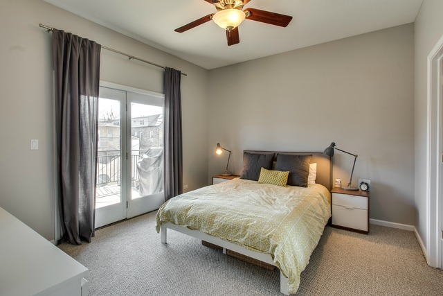 2629 West Haddon Avenue, Unit 2 Chicago, IL 60622 - Photo 4 of 8 a bedroom with a large bed and a chandelier